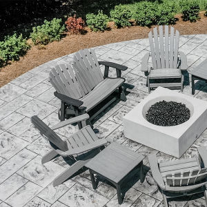 A residential patio area with six Adirondack chairs around a fire pit.